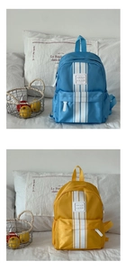 Detail of color-block school backpack showing blue-yellow canvas and side pockets