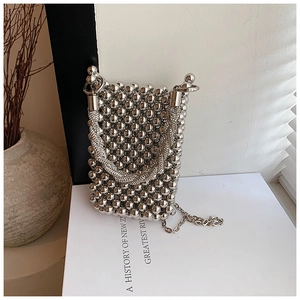 Macro shot of silver beaded bucket bag with rhinestone handle and chain strap detail