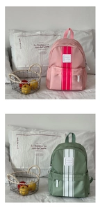 Detail view of stylish pink and army green kids backpacks with striped nylon material