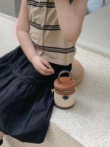 Detail einer Mini-Zylindertasche für Kinder mit Leder im Colorblock-Design und Goldbeschlägen