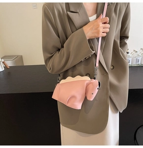 Sac bandoulière rose en forme de rhinocéros porté par un mannequin, design créatif en PU