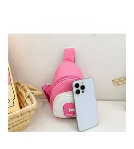 Mini pink and white kids chest bag size comparison with a smartphone on a clean background