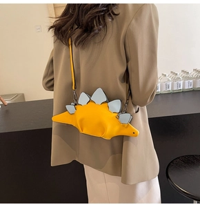 Detail of yellow stegosaurus crossbody bag featuring contrasting light blue back fins