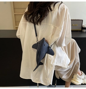 Détail d'un sac à bandoulière créatif en forme de requin en cuir bleu mat avec fermeture