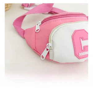 Close-up of a pink kid waist bag showing a smooth white plastic zipper and nylon texture