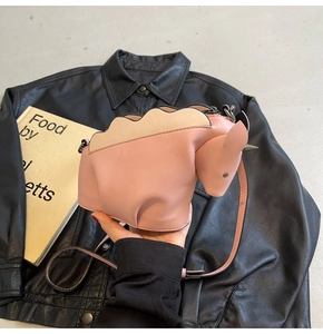 Gros plan du sac à bandoulière créatif en forme de dinosaure rose à texture mate