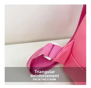Detail showing triangle reinforced stitching and white adjustable buckle on a pink bag