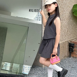 Ensemble mode enfant deux pièces avec haut polo sans manches et jupe plissée gris foncé