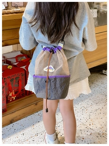 Close-up of kids mesh drawstring backpack with grey canvas base and purple trim detailing