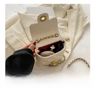 Detail view of the interior capacity of this white quilted chain bag for daily essentials