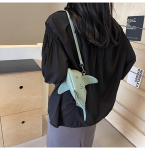 Détail du sac à bandoulière vert clair en forme de requin porté par un mannequin
