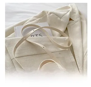 Detail of cream children's shoulder bag featuring a large pink bow on a tweed jacket
