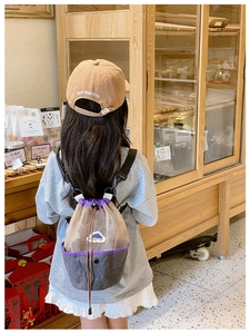 Detail of a mesh drawstring backpack for kids and a matching khaki baseball cap