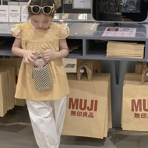 Girl wearing yellow puff sleeve top with floral embroidery and white pants set
