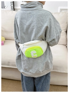 Detail of kids chest bag showing contrast white and green design with bold C letter logo