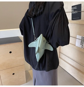 Vue arrière d'un mannequin portant un sac bandoulière requin vert menthe dans une pièce