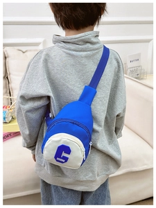 Rear view of a child wearing a navy and white crossbody bag with letter C printing