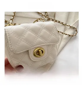 Close-up of cream quilted faux leather mini bag with gold chain strap and metal turn-lock