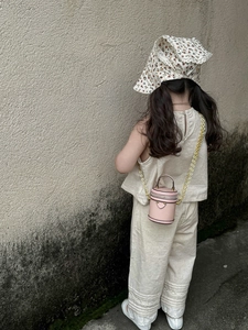 Rosa runde Mini-Tasche für Kinder, kombiniert mit einem beigen Leinen-Outfit