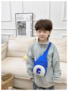 Detail of blue and white kids chest bag with letter C print shown in home setting