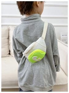 Detail view of kids color-block chest bag with letter C patch and neon green pocket