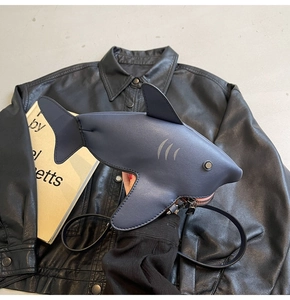 Détail du sac bandoulière en forme de requin avec cuir mat et rivets argentés