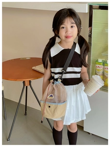 Detail view of kids drawstring mesh bag with khaki base and adjustable black strap