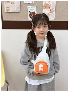 Kids chest bag with orange contrast pocket and adjustable strap shown from a 45-degree angle