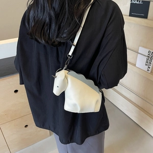Sac bandoulière licorne chic en cuir crème avec détails vagues bleues porté par mannequin