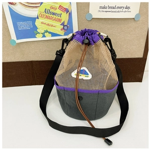 Close-up of mesh and canvas drawstring bucket bag with purple cords on vintage background
