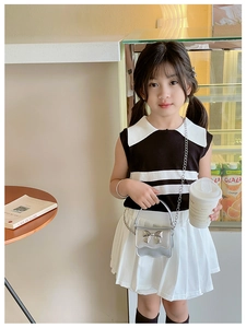 Detail of silver metallic chain bag with bow accessory and striped kids clothing