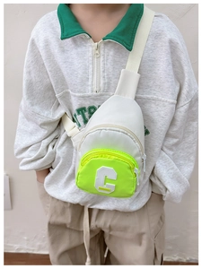 Close-up of children's white and neon green chest bag with adjustable strap and C logo