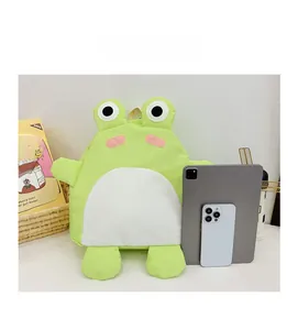Detail of green frog plush backpack showing soft texture beside a tablet for size reference