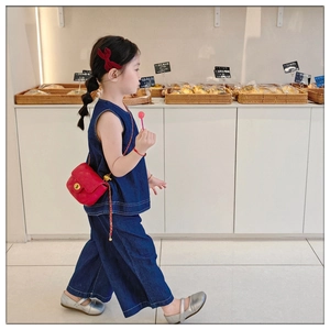 Detail of red quilted mini chain bag with gold buckle on a stylish girl outfit