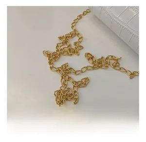 Detailed macro view of glossy golden metal chain strap on white crocodile pattern bag