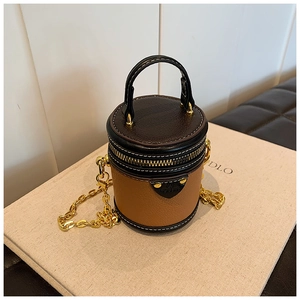 Detailansicht der Mini-Zylindertasche mit braun-schwarzem Colorblocking und Metallkette