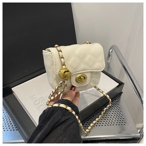 Detail of white quilted mini shoulder bag with gold chain and adjustable ball buckle