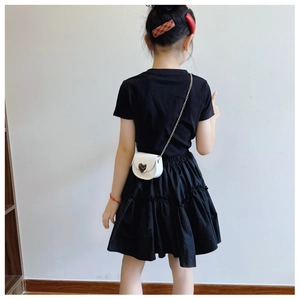 Detail of a white leather crossbody heart bag with gold chain for children's outfit