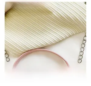 Macro view of pink PU leather handbag with smooth handle and silver metal chain strap