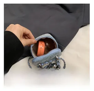 Détail montrant la capacité interne d'un mini sac chaîne en jean bleu pour enfant