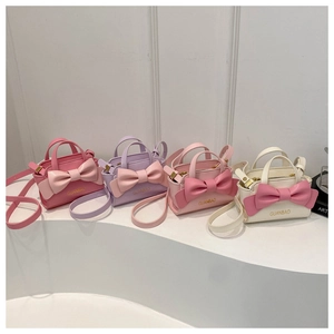 Four colorful kids' mini crossbody bags with large bows in pink, purple, and cream colors