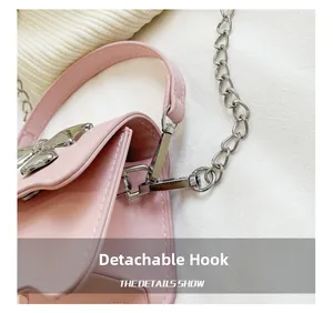 Close-up of pink synthetic leather bag with detachable silver metal hook and chain