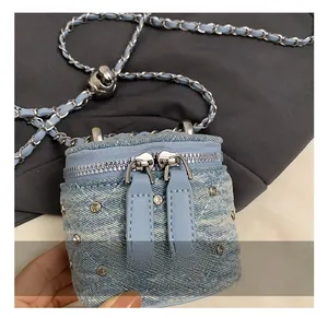 Détail du sac bandoulière en denim bleu clair avec strass argentés et chaîne