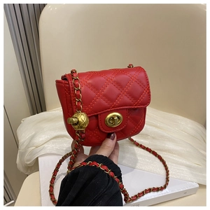 Close-up of red quilted mini crossbody bag with golden ball adjustable chain strap