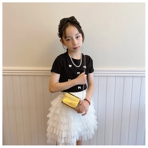 Kids fashion set with black T-shirt, white mesh skirt, and gold stone pattern chain bag