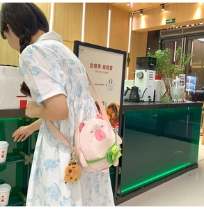 Detail of pink plush pig crossbody bag with cute embroidery and turtle pendant