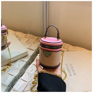 Detail einer pink-beigen Mini-Zylindertasche mit Goldkette und HOUJIN-Metalllogo