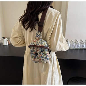 Détail du sac bandoulière vintage à fleurs avec sangle marron et fermeture à cordon