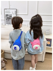 Detail view of pink and blue stylish kids chest bags with adjustable straps in lifestyle scene