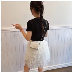 Detail of white crocodile texture chain bag paired with layered tulle tutu princess skirt